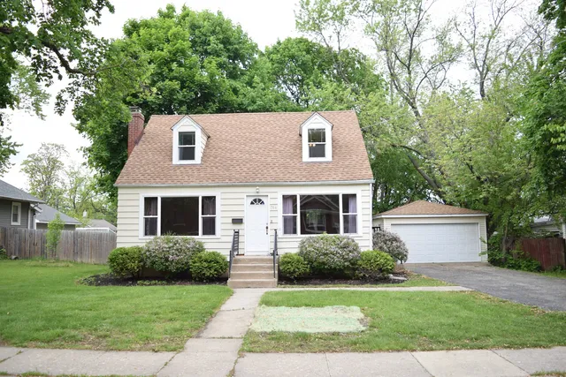 a front view of a house with a yard and a garage