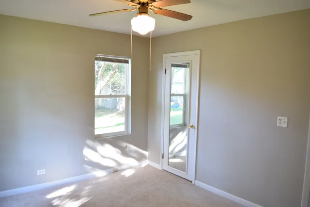 a view of a livingroom with a chandelier fan and a window