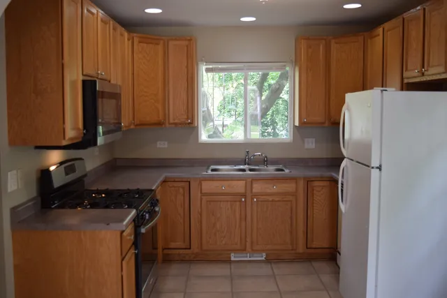 a kitchen with stainless steel appliances granite countertop a refrigerator sink and cabinets