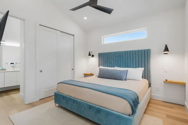 a bedroom with a bed and painting on the wall