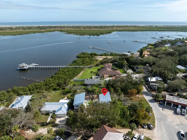an aerial view of ocean and residential houses with outdoor space