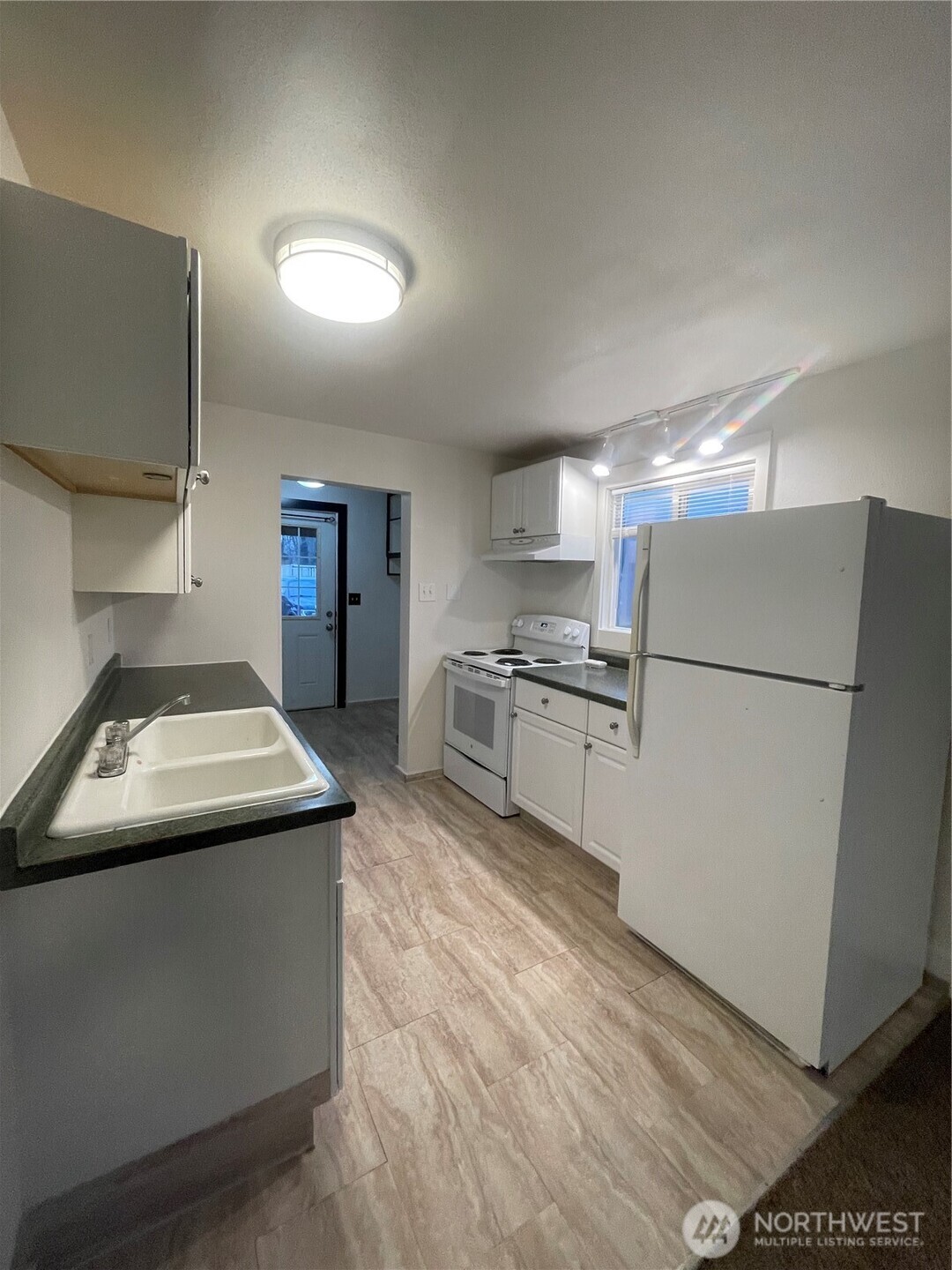 903 Howard Street Raymond, WA 98577 - Photo 4 of 11 a kitchen with refrigerator a stove and a refrigerator