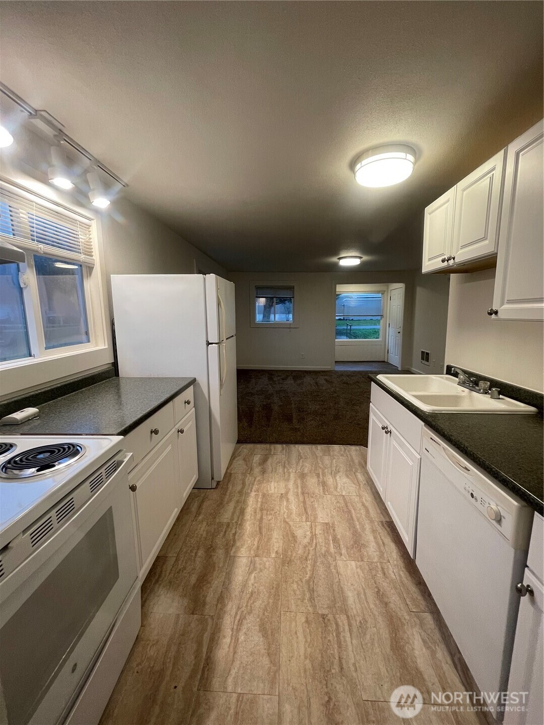 903 Howard Street Raymond, WA 98577 - Photo 5 of 11 a large kitchen with a stove a sink dishwasher and a refrigerator