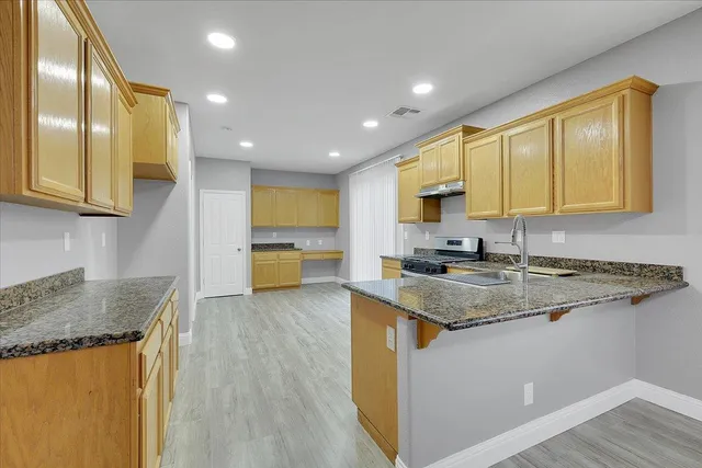a kitchen with stainless steel appliances granite countertop wooden cabinets and a granite counter tops