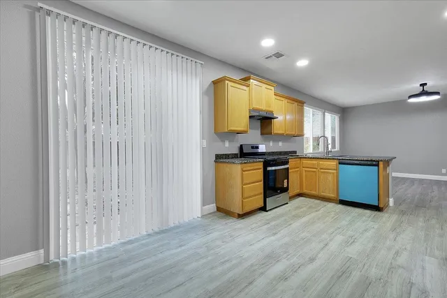 a kitchen with stainless steel appliances a sink a stove top oven a counter space and cabinets