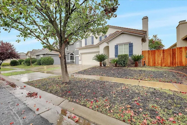 a front view of house with yard and trees around