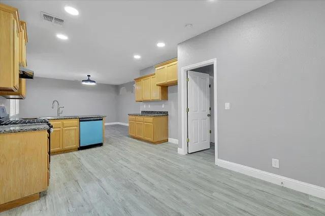 a kitchen with stainless steel appliances granite countertop a refrigerator a sink and a stove