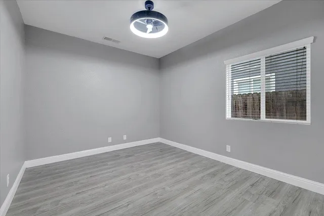 wooden floor in an empty room with a window