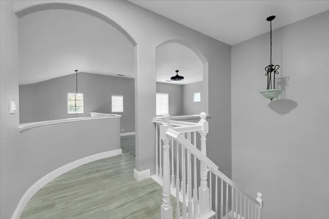 a view of a hallway with wooden floor and staircase