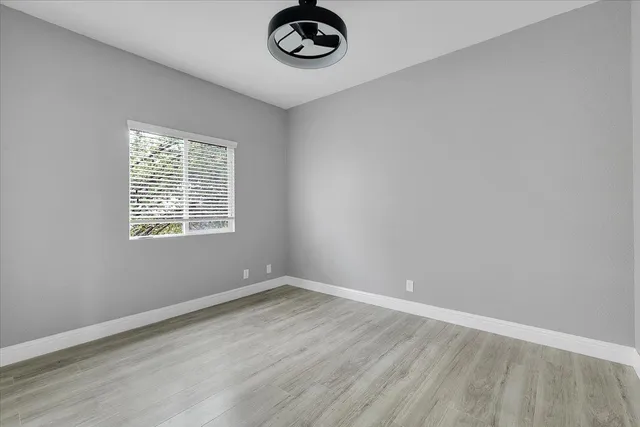 a view of a small space with wooden floor and a window