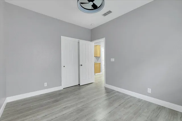 a view of an empty room with wooden floor