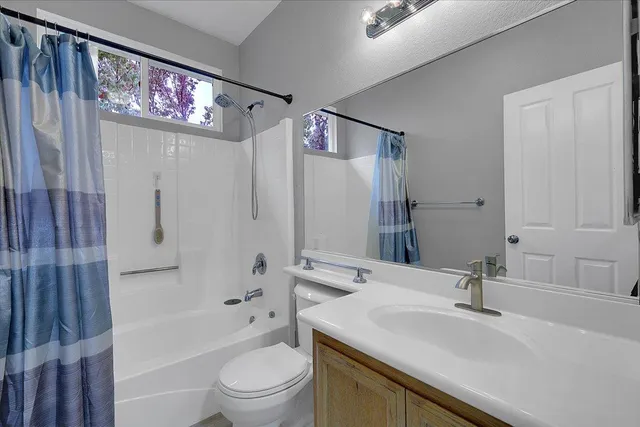 a bathroom with a sink a toilet a tub and shower