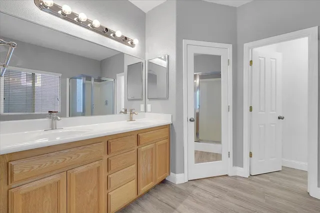a spacious bathroom with a double vanity sink mirror and shower