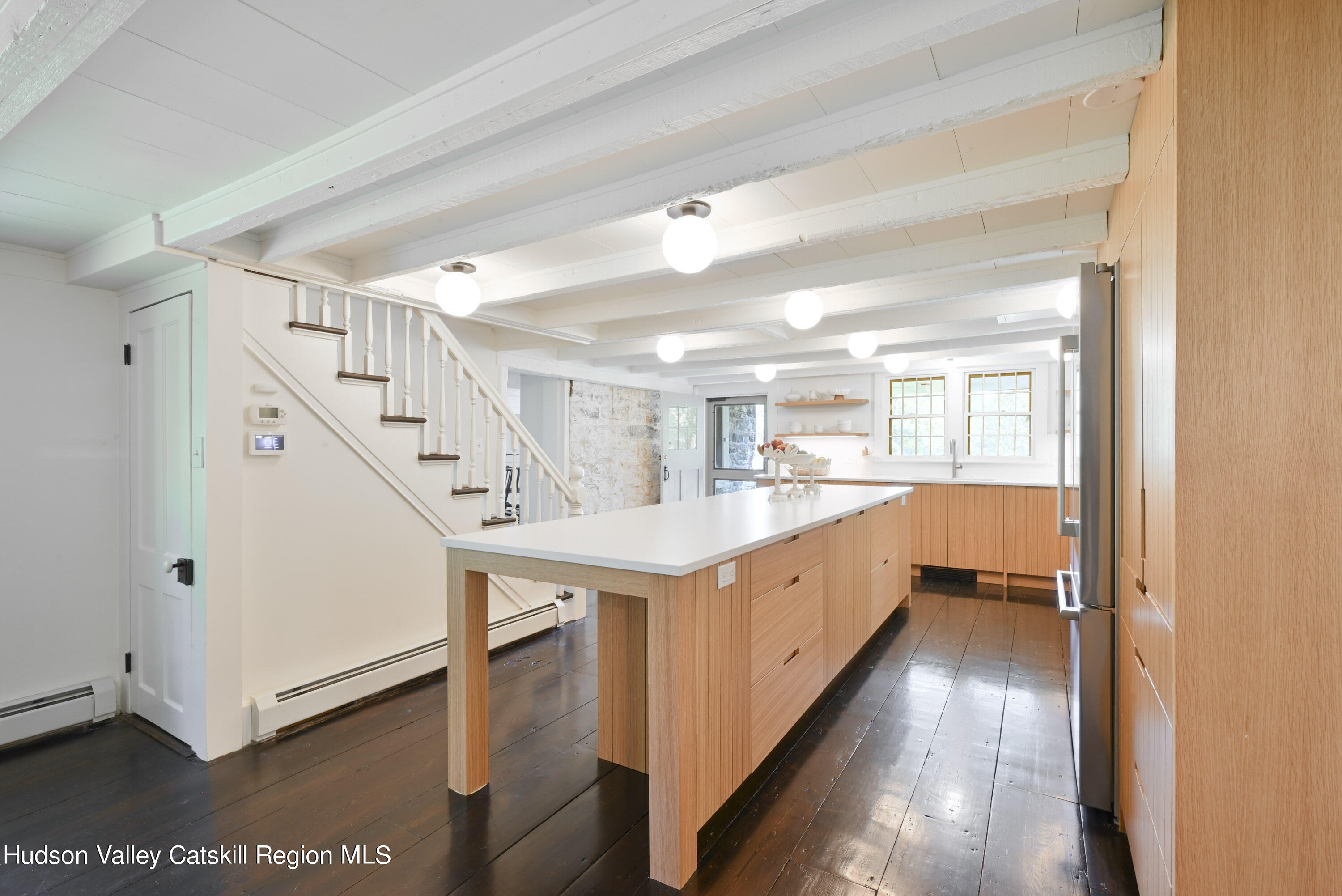 351 Peak Road Stone Ridge, NY 12484 - Photo 12 of 32 a large white kitchen with wooden floor and white cabinets
