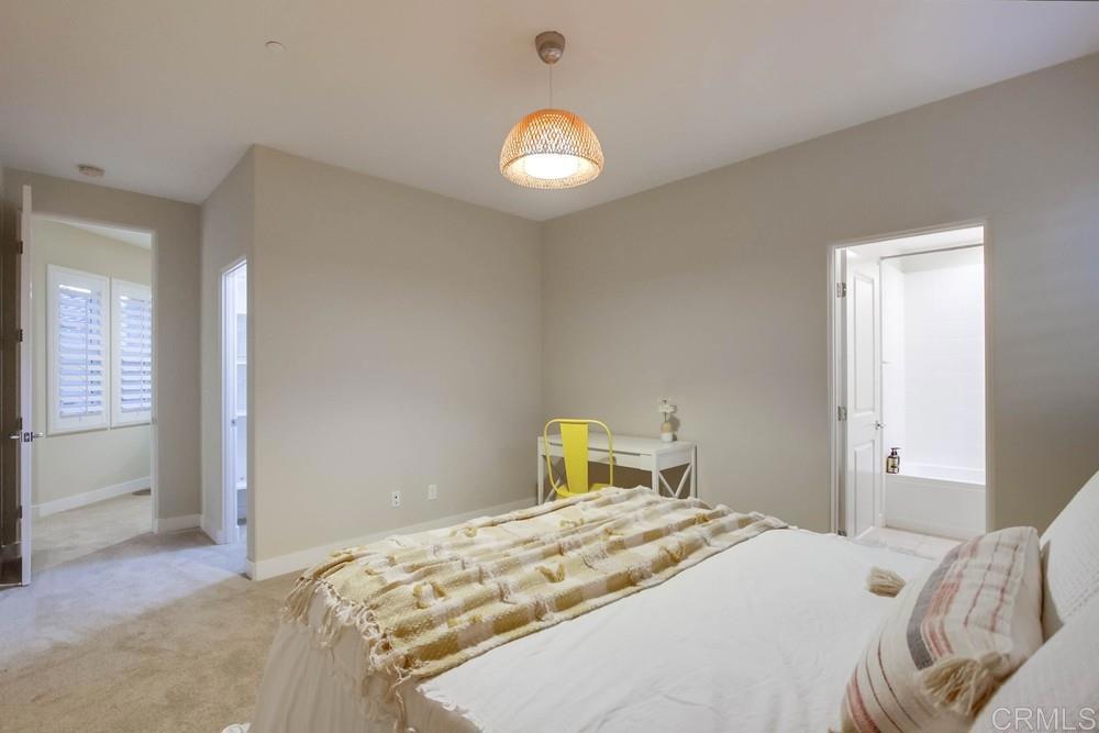 7177 Sitio Corazon Carlsbad, CA 92009 - Photo 31 of 41 a bedroom with a bed and a chandelier