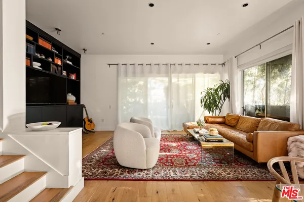 a living room with furniture a rug and a large window