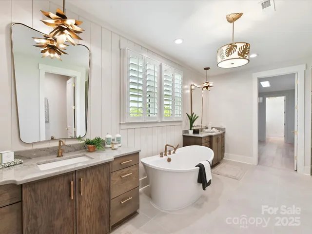 a bathroom with a sink a chandelier and a bathtub
