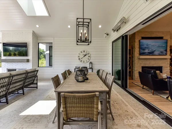 a living room with furniture a flat screen tv and kitchen view