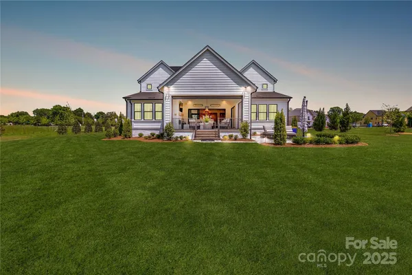 a front view of a house with a garden and trees