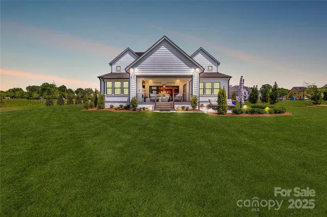 a front view of a house with a garden and trees