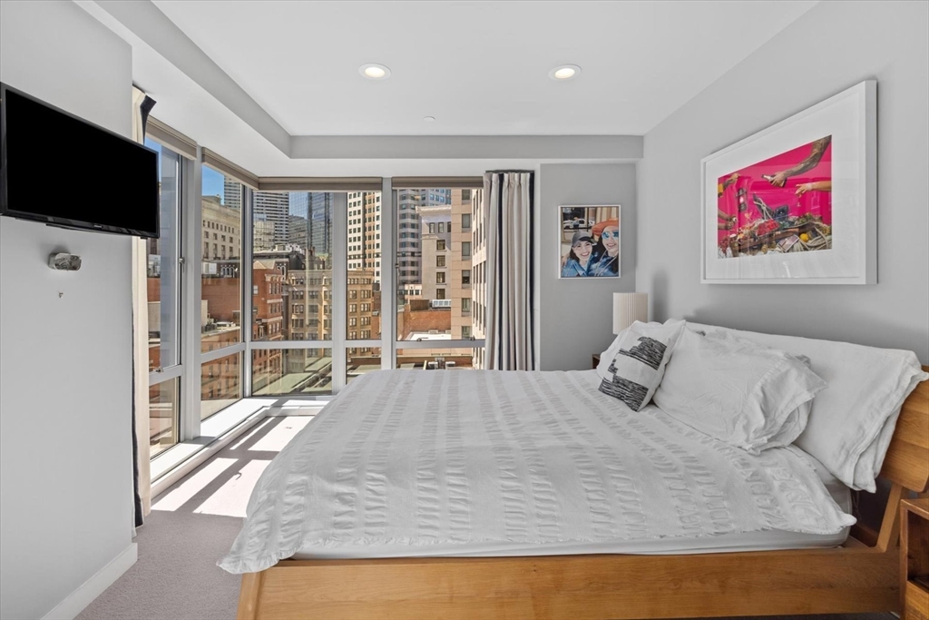 80 Broad Street, Unit 808 Boston, MA 02110 - Photo 15 of 27 a bedroom with a bed and a flat screen tv