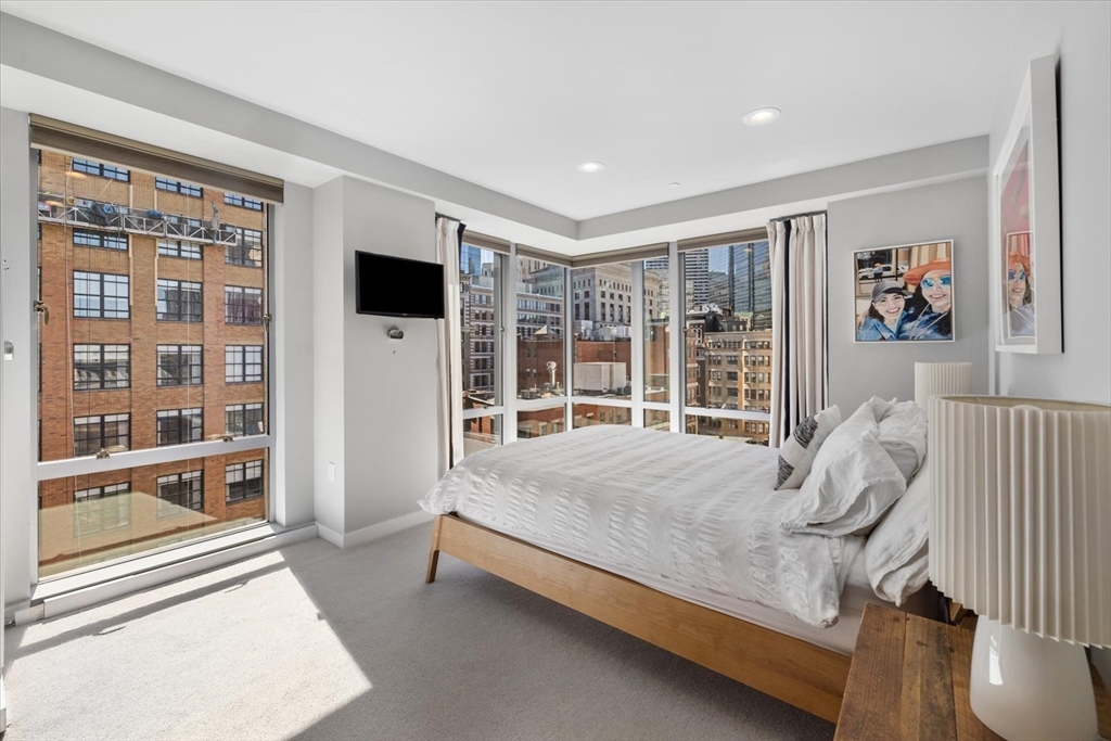 80 Broad Street, Unit 808 Boston, MA 02110 - Photo 16 of 27 a bed sitting in a spacious bedroom next to a large window