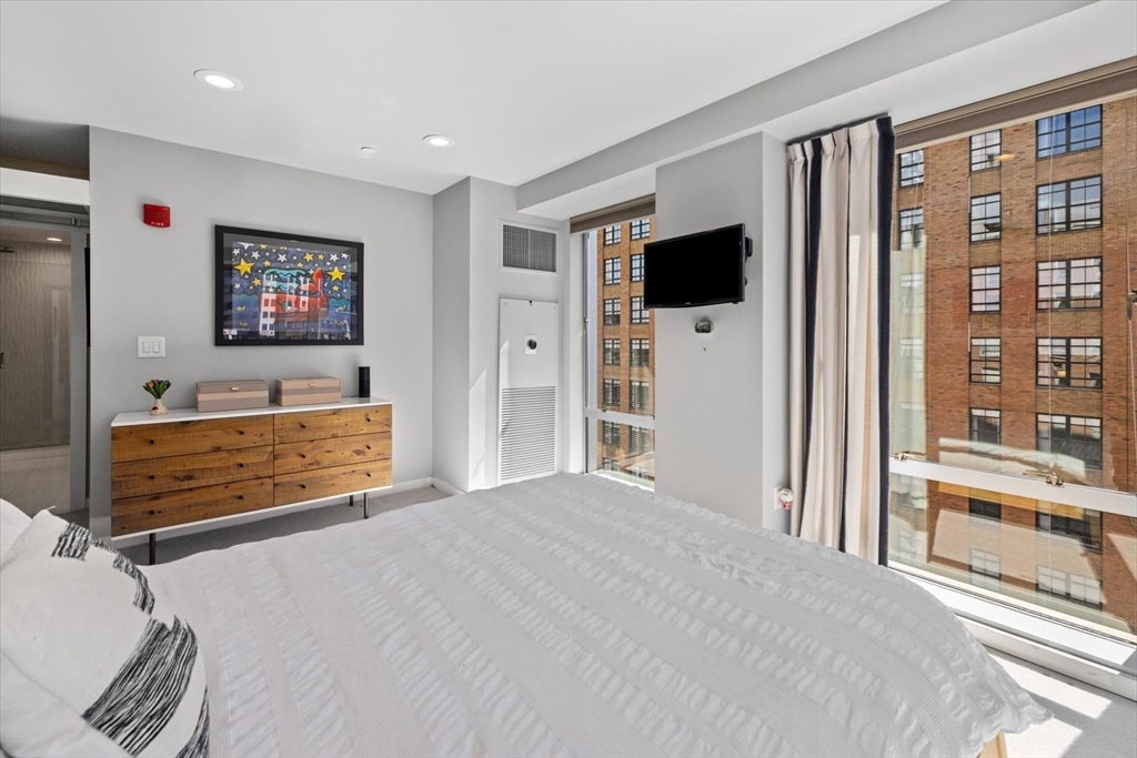 80 Broad Street, Unit 808 Boston, MA 02110 - Photo 17 of 27 a bedroom with furniture and flat screen tv