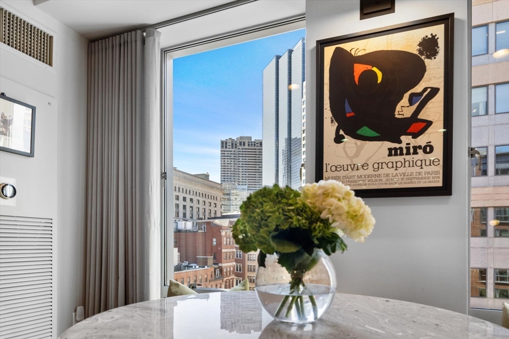80 Broad Street, Unit 808 Boston, MA 02110 - Photo 8 of 27 a vase of flowers sitting on a table in front of a window