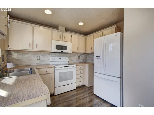 a kitchen with kitchen island a sink stainless steel appliances and cabinets