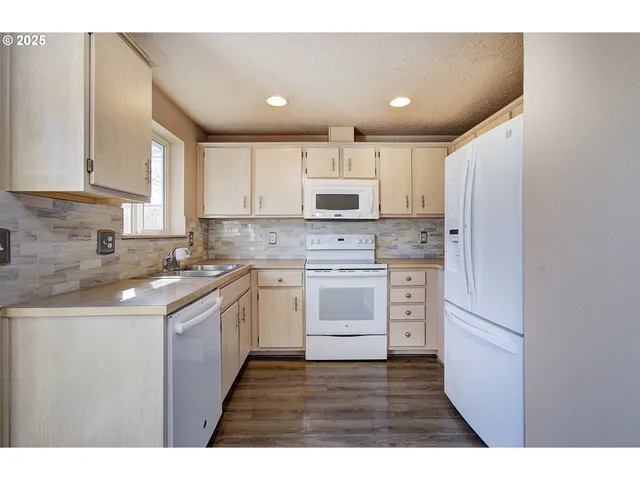 a kitchen with kitchen island granite countertop white cabinets and stainless steel appliances
