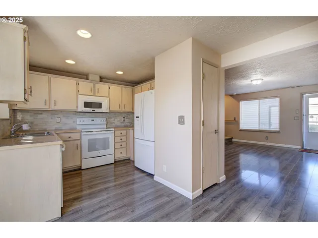 a kitchen with a refrigerator and a stove top oven