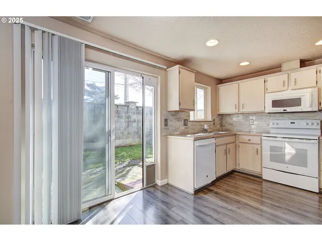 a kitchen with a refrigerator and white cabinets