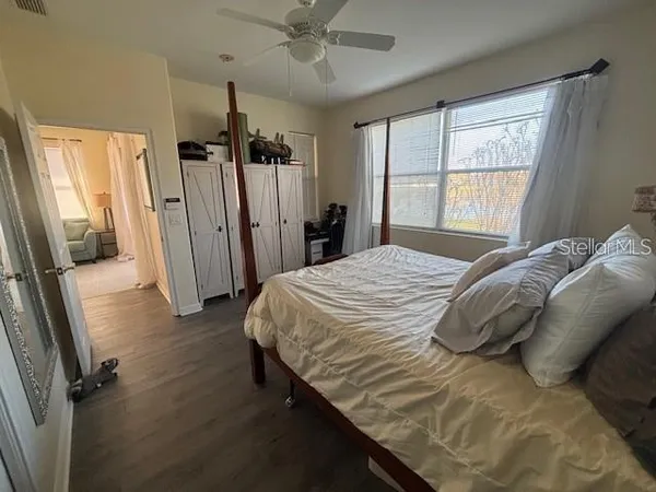 a bedroom with a bed closet and a large window