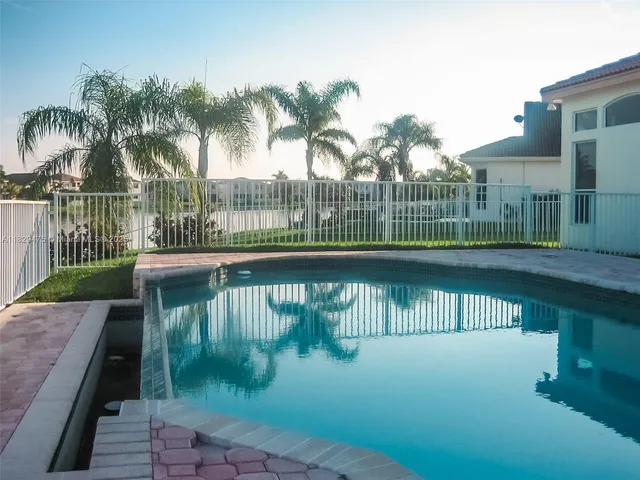 a view of a lake with a big yard and palm trees