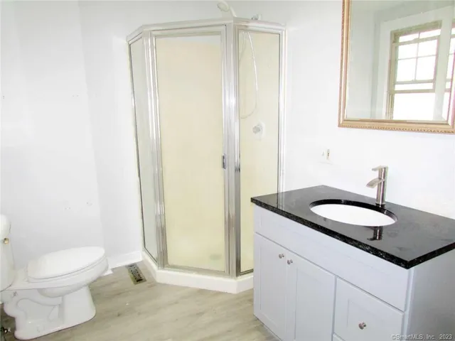 a bathroom with a granite countertop sink toilet and shower