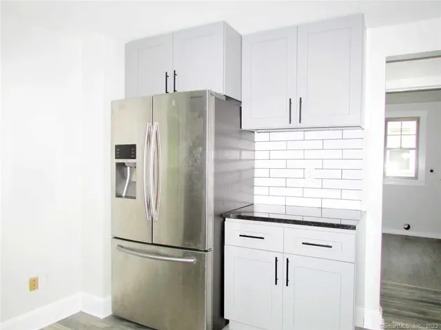 a kitchen with stainless steel appliances granite countertop a refrigerator and a stove