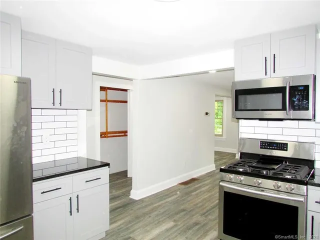 a kitchen with granite countertop a stove and a sink