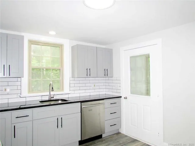 a kitchen with granite countertop cabinets and window