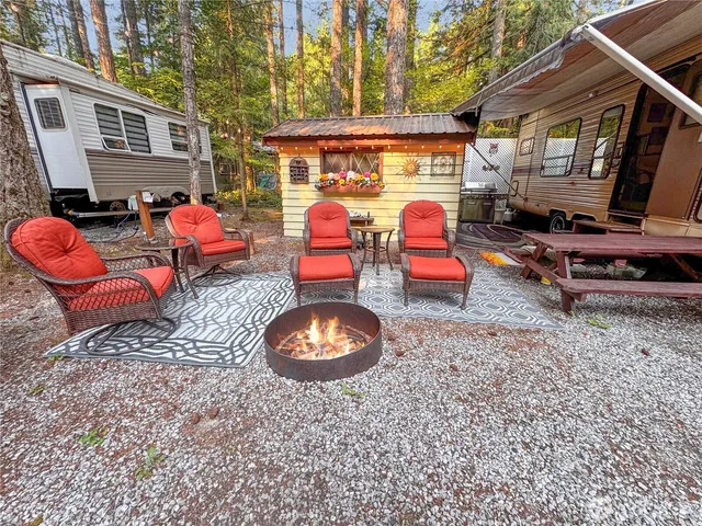 a backyard of a house with fire pit and outdoor seating