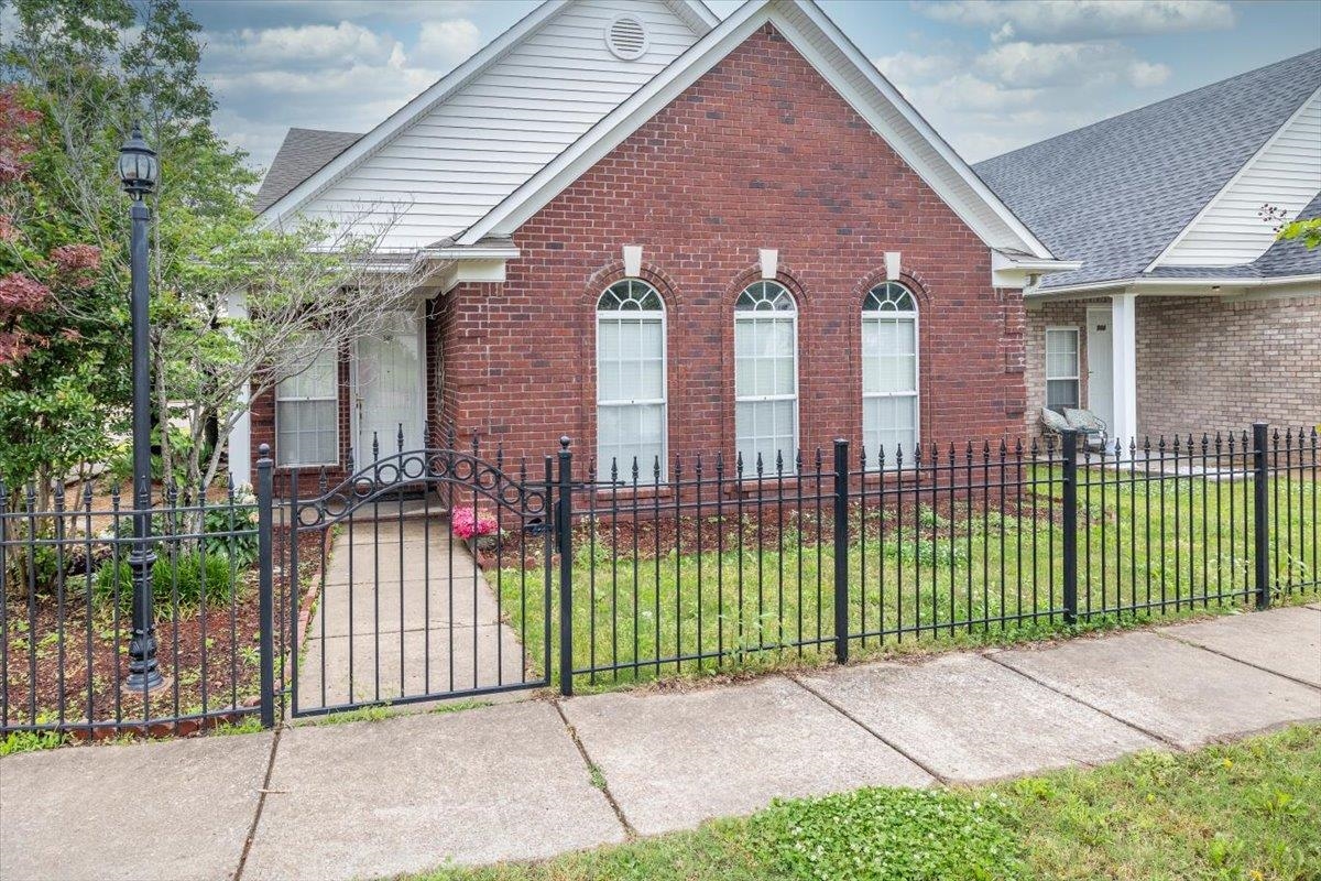 346 Beaver Road Munford, TN 38058 - Photo 1 of 24 View of front facade featuring a front lawn, a fenced front yard, brick siding, and a gate