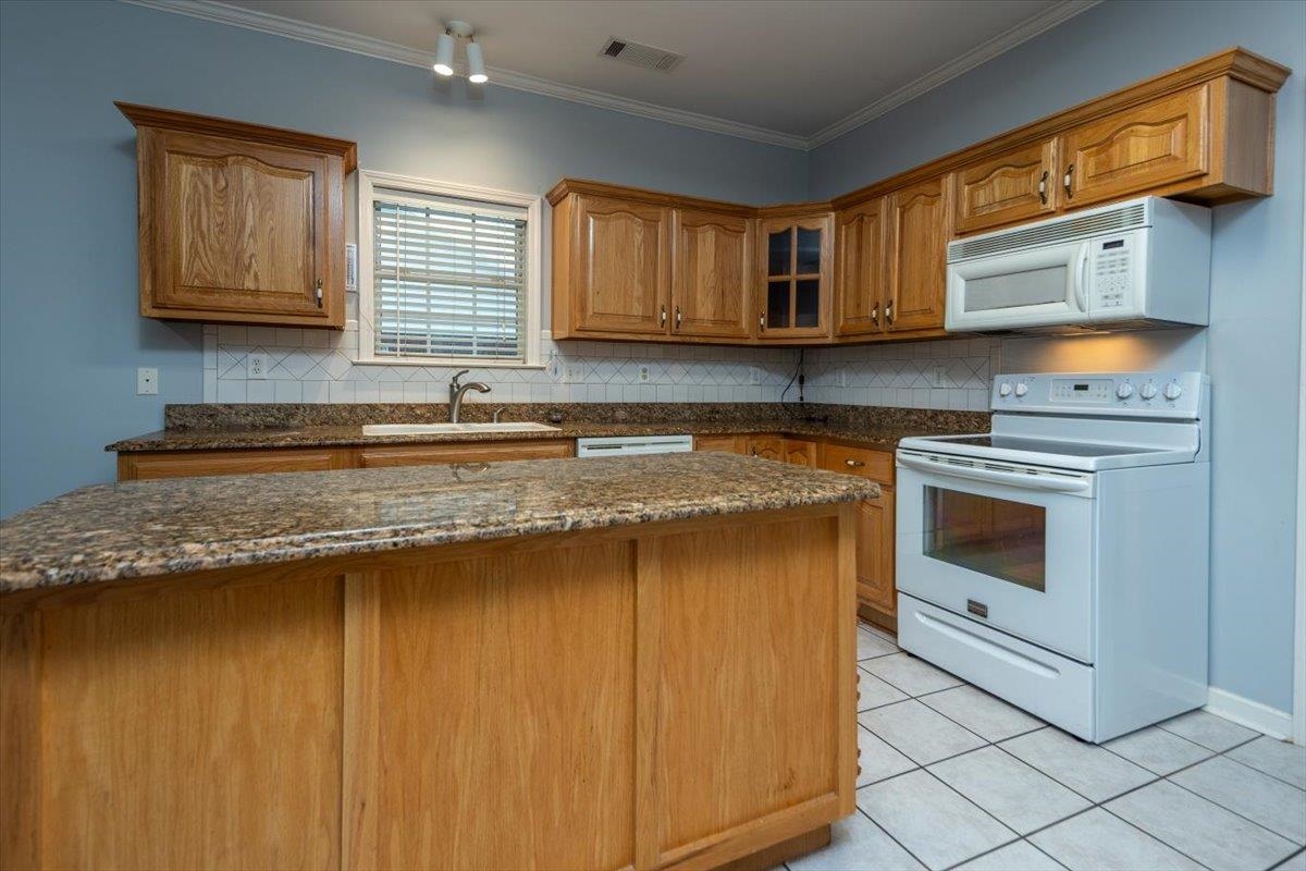 346 Beaver Road Munford, TN 38058 - Photo 12 of 24 Kitchen featuring a sink, white appliances, visible vents, and tasteful backsplash