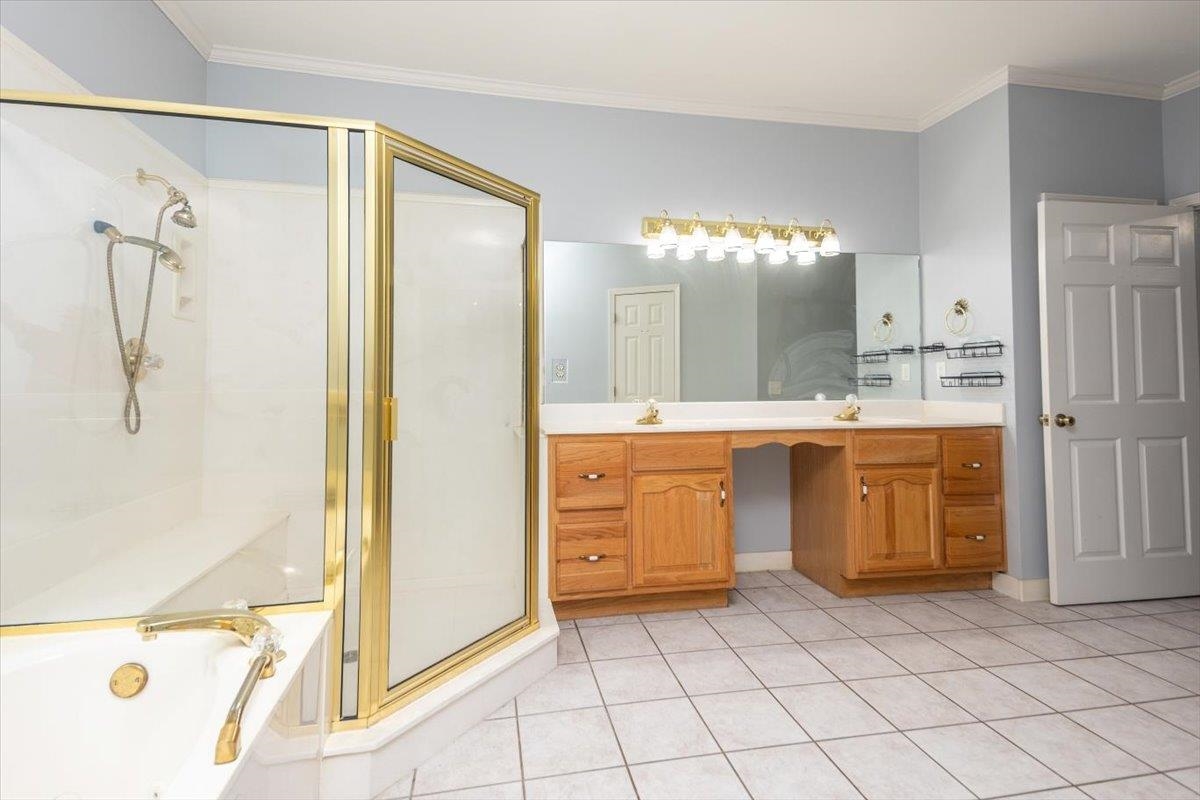 346 Beaver Road Munford, TN 38058 - Photo 16 of 24 Bathroom featuring a sink, double vanity, a garden tub, and a separate shower stall.