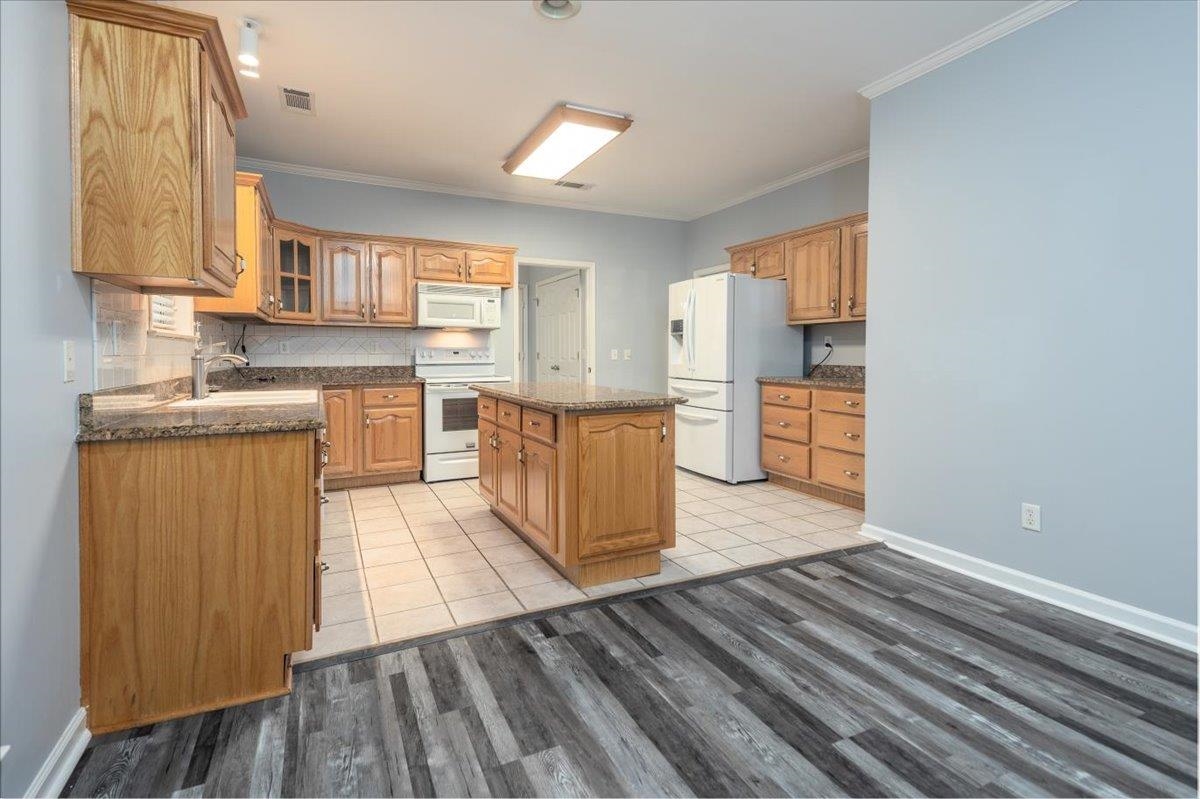 346 Beaver Road Munford, TN 38058 - Photo 10 of 24 Kitchen featuring glass insert cabinets, a center island, visible vents, white appliances, and light wood-style floors