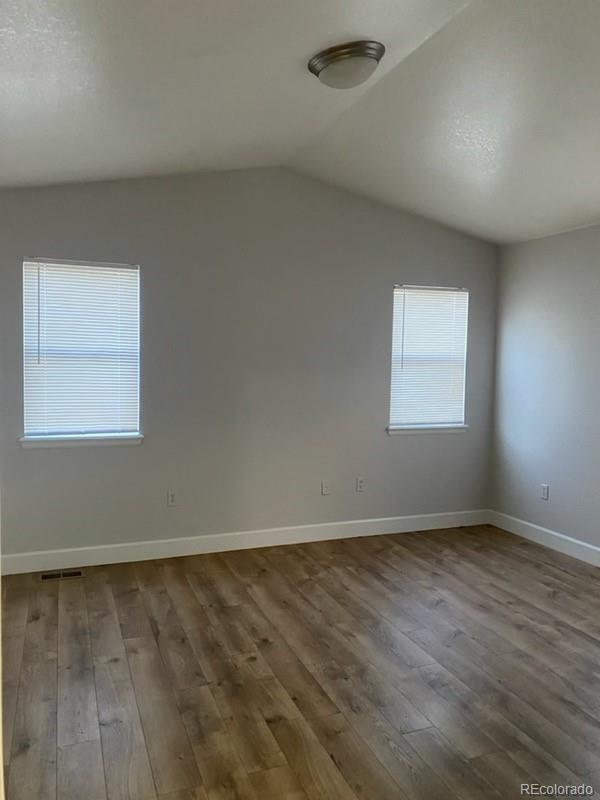 4580 West Alameda Avenue Denver, CO 80219 - Photo 5 of 18 an empty room with wooden floor and windows