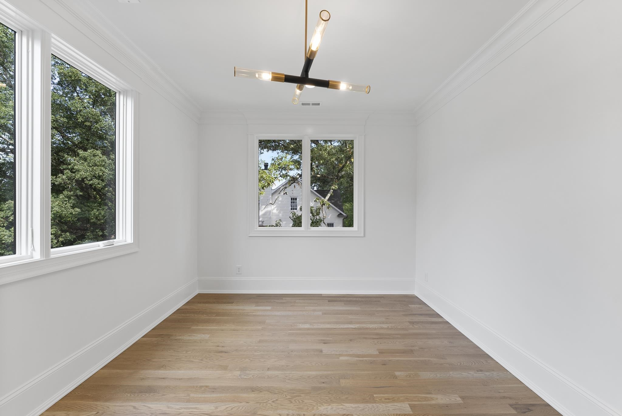 1419 Chester Road Raleigh, NC 27608 - Photo 36 of 41 an empty room with wooden floor a ceiling fan and windows