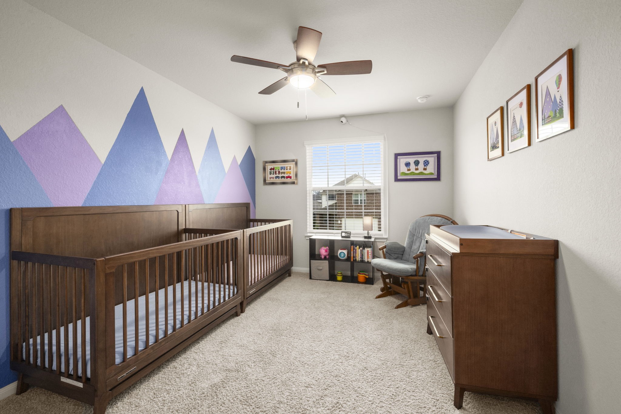 4915 Blue Jacaranda Way Spring, TX 77373 - Photo 20 of 30 Bedroom 2 - Cozy nursery or children's room is brightened with a colorful mountain mural, plush carpet, ceiling fan and a window overlooking the front yard.