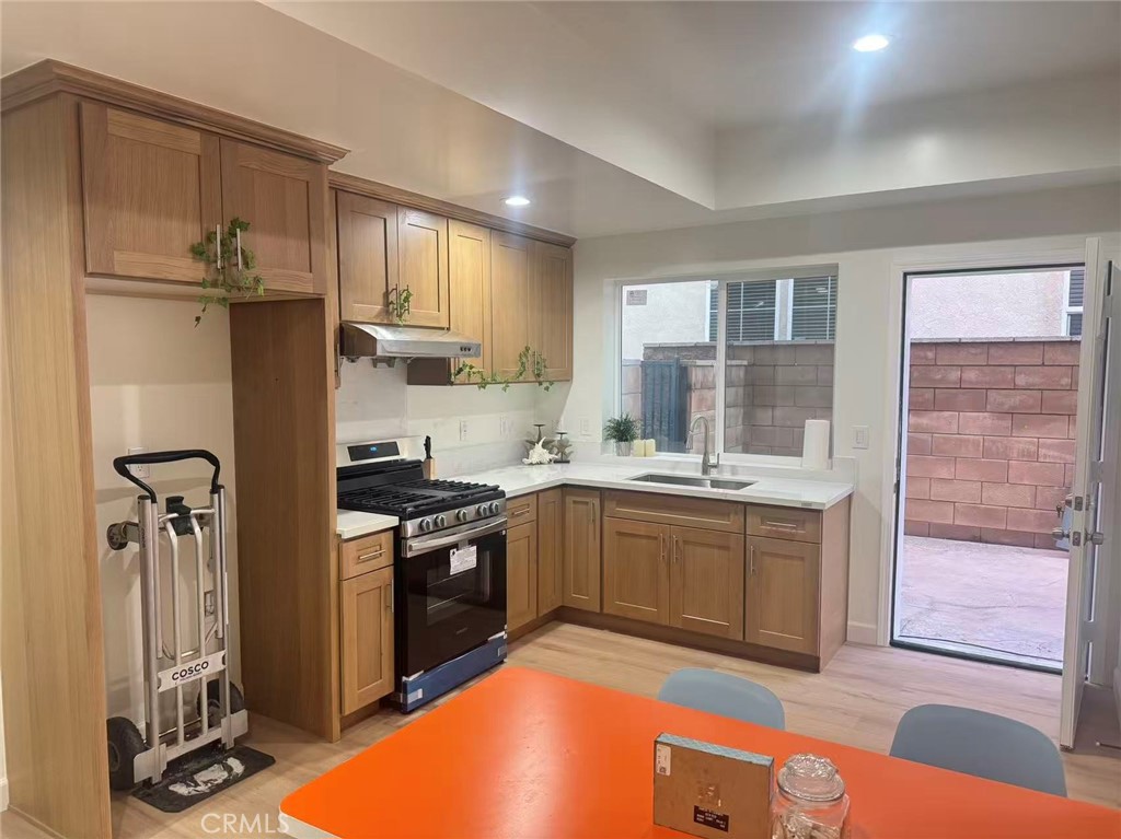 6805 Edinburgh Road Eastvale, CA 92880 - Photo 30 of 47 a kitchen with stainless steel appliances granite countertop a sink stove and refrigerator