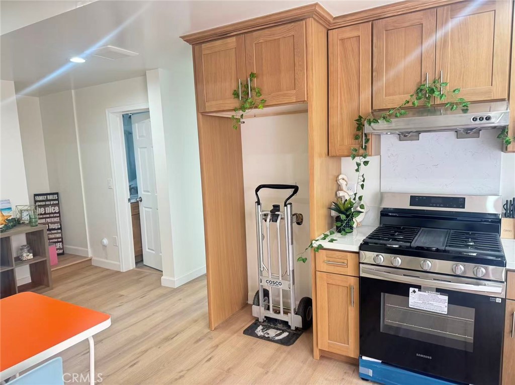 6805 Edinburgh Road Eastvale, CA 92880 - Photo 33 of 47 a kitchen with stainless steel appliances granite countertop a stove and a refrigerator