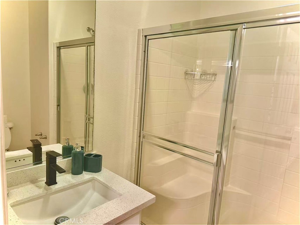 6805 Edinburgh Road Eastvale, CA 92880 - Photo 44 of 47 a bathroom with a granite countertop sink and a mirror