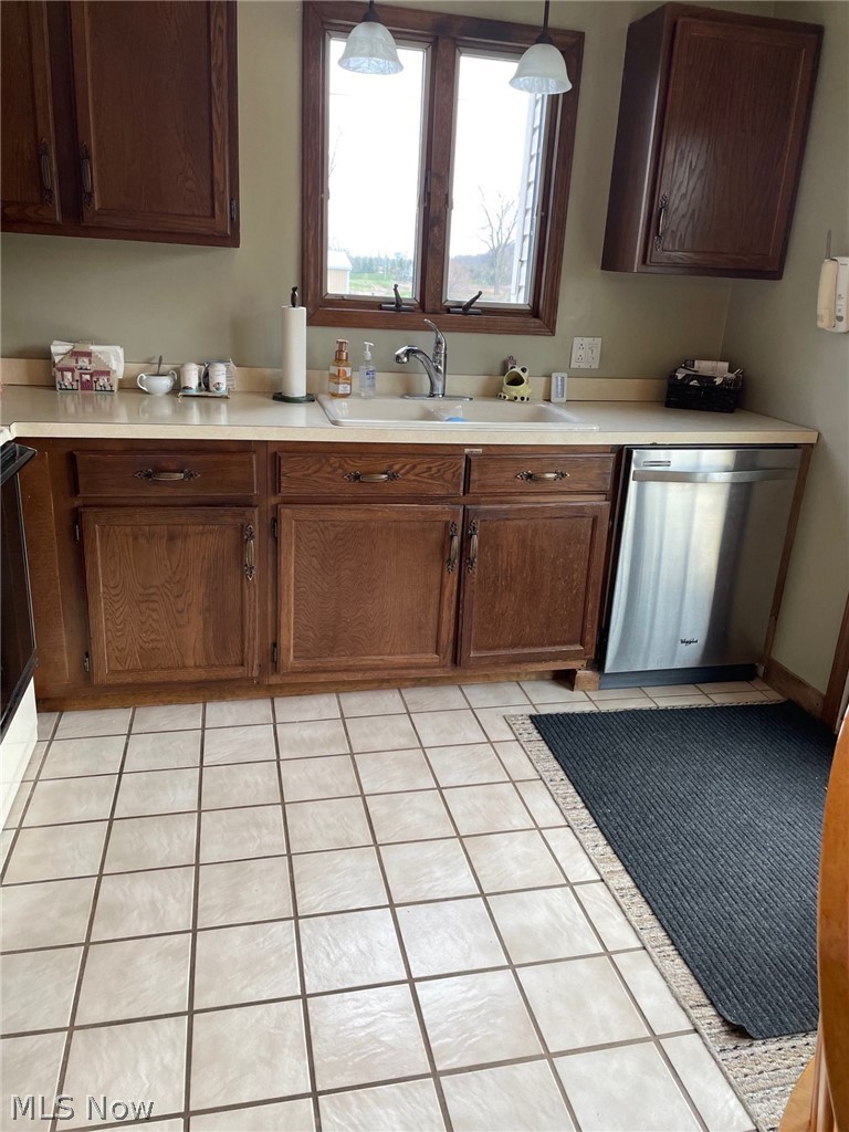3100 Station Road Medina, OH 44256 - Photo 15 of 15 Kitchen with decorative light fixtures, dark brown cabinets, sink, light tile floors, and dishwasher
